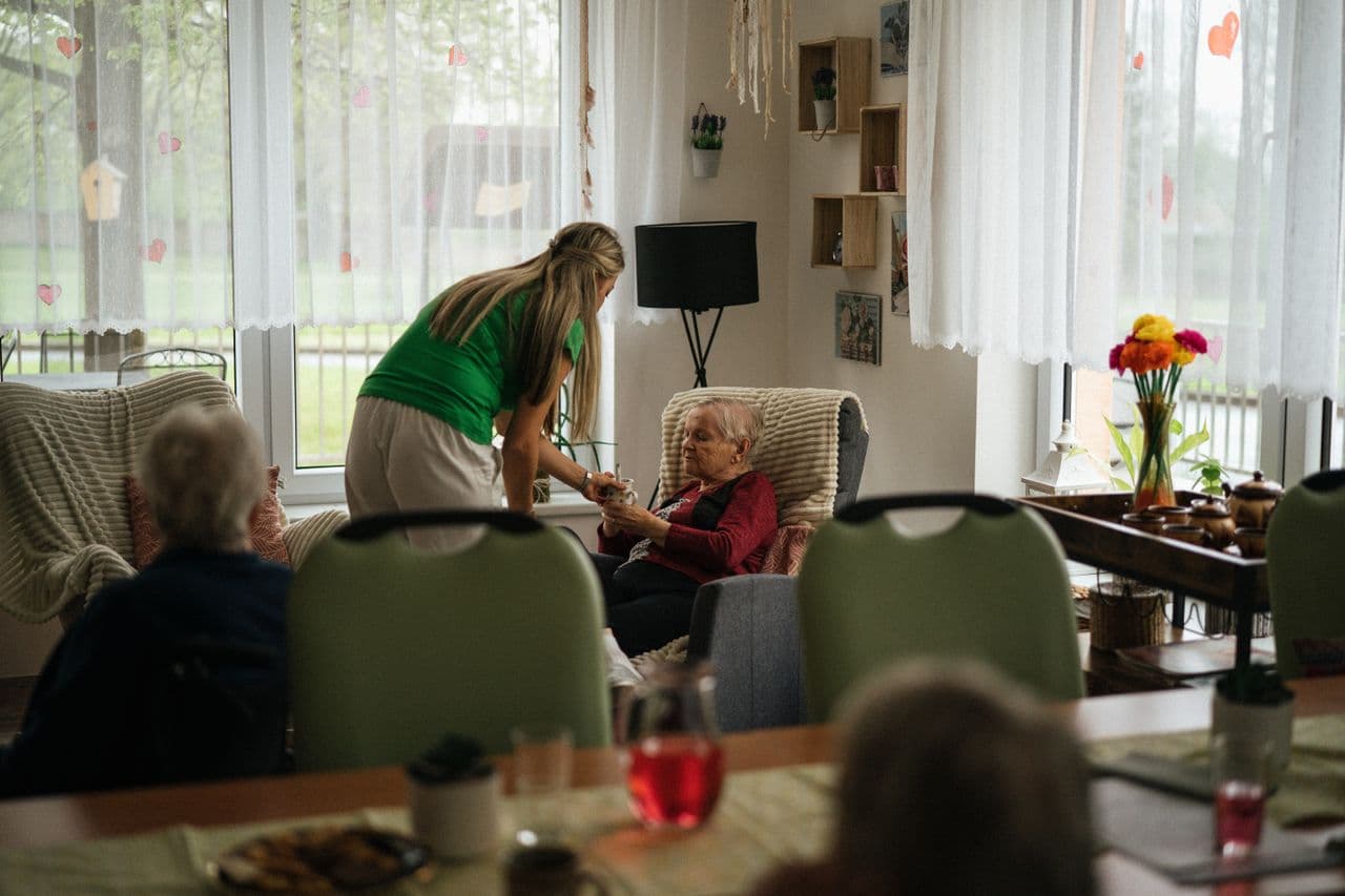 Caregiver with an elderly resident by a window at home