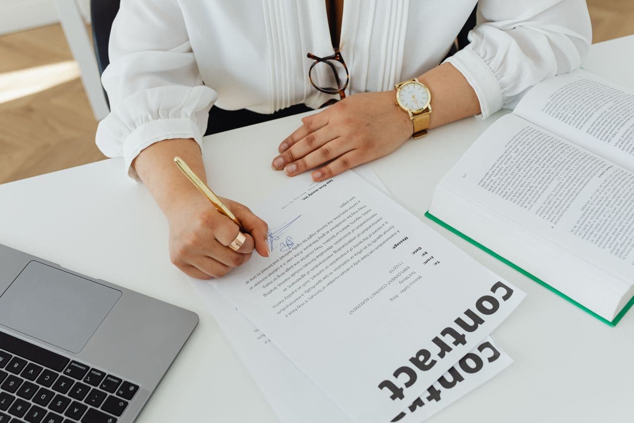 Hands signing an employment document