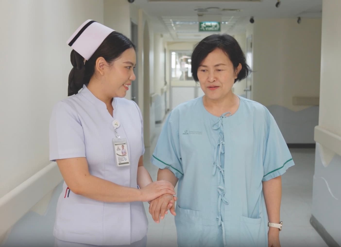 Care nurse walking with an elderly woman